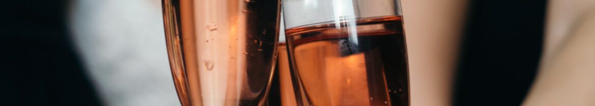 pexels-cristian-rojas-8459368 Two people toast with glasses of rosé sparkling wine at a celebration.